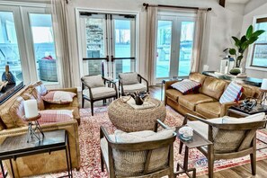A cozy living room with a leather sofa, wicker ottoman, and a coffee table. - Rehoboth Beach Vacation Rental Luxury House at Arbor Lyn 6BR Home Sleeps 14 * New Listing * (Rehoboth Beach)