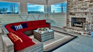 A modern living room with a red sectional sofa, a coffee table, and a stone fireplace.