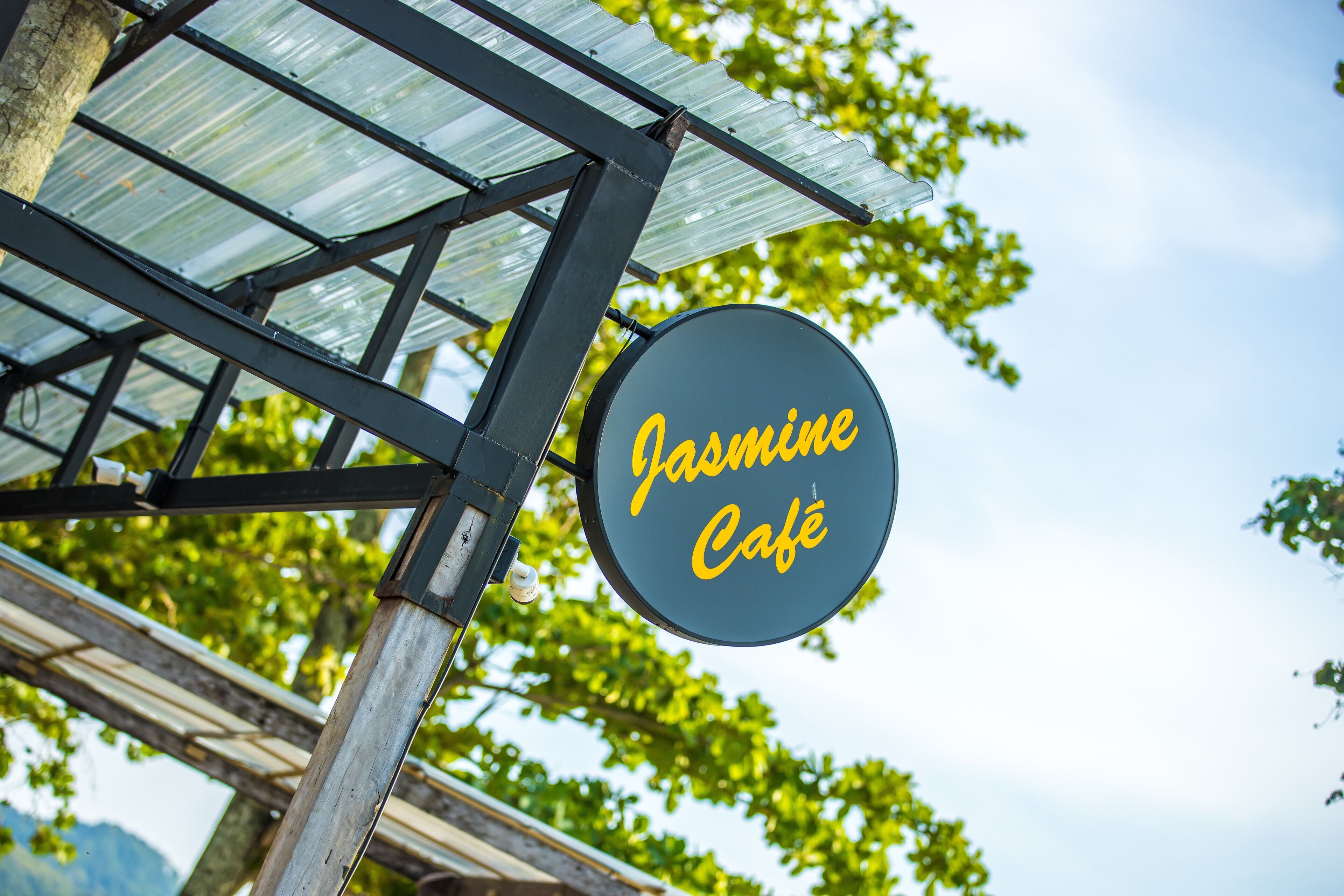 Schild für das Jasmine Café mit Metallkonstruktion und Glasscheiben.
