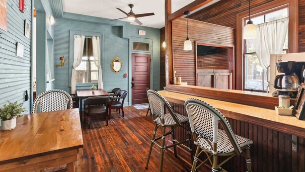 Un intérieur rustique avec un bar en bois, un coin repas et un ventilateur de plafond.
