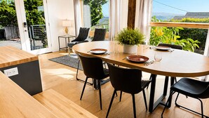 Ein moderner Essbereich mit einem runden Tisch, schwarzen Stühlen und einem Blumentopf.