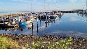 Ein Yachthafen mit vertäuten Booten, ruhigem Wasser und einer felsigen Küste.