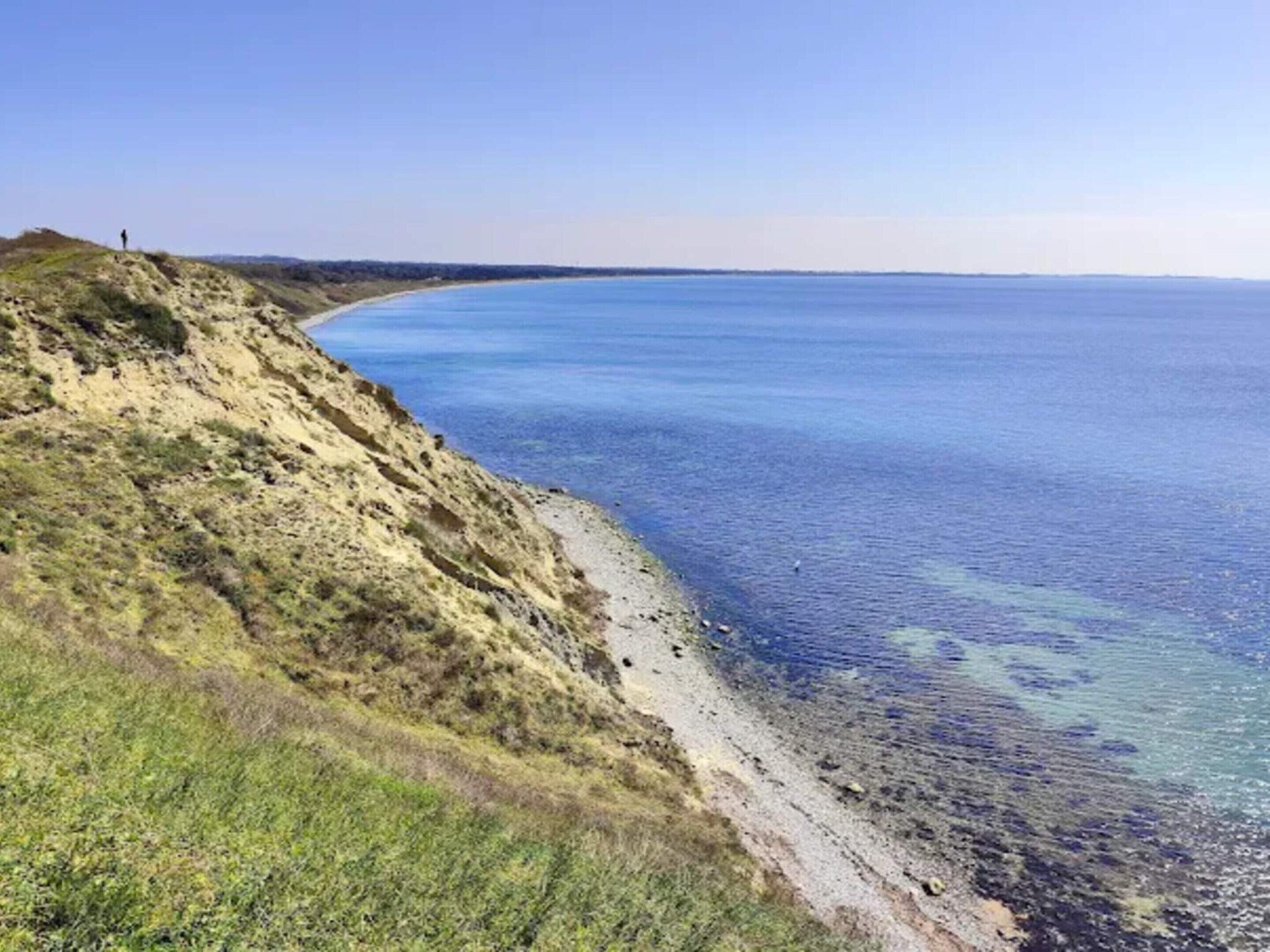 Un paysage côtier offrant une vue dégagée sur la mer et une plage de sable.