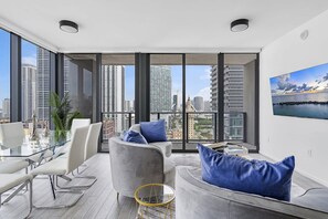 A modern living room with a city view, large windows, and contemporary furniture.