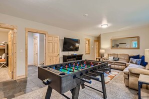 A living room with a foosball table, a television, and a sofa. - Twin Creek Lodge (Breckenridge)
