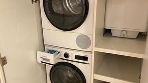Lavadora secadora compacta, blanca, de dos puertas con panel de control en la puerta superior y otro en la puerta inferior.