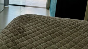 Ein Zimmer mit einem großen Bett, einer Glastür zum Poolbereich und Blick auf den Himmel.