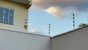 Ein modernes Gebäude mit Flachdach, einem Fenster mit Blick und einem Schild an der Wand.