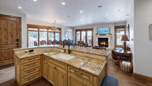 A spacious kitchen with granite countertops, wooden cabinets, and a large island.