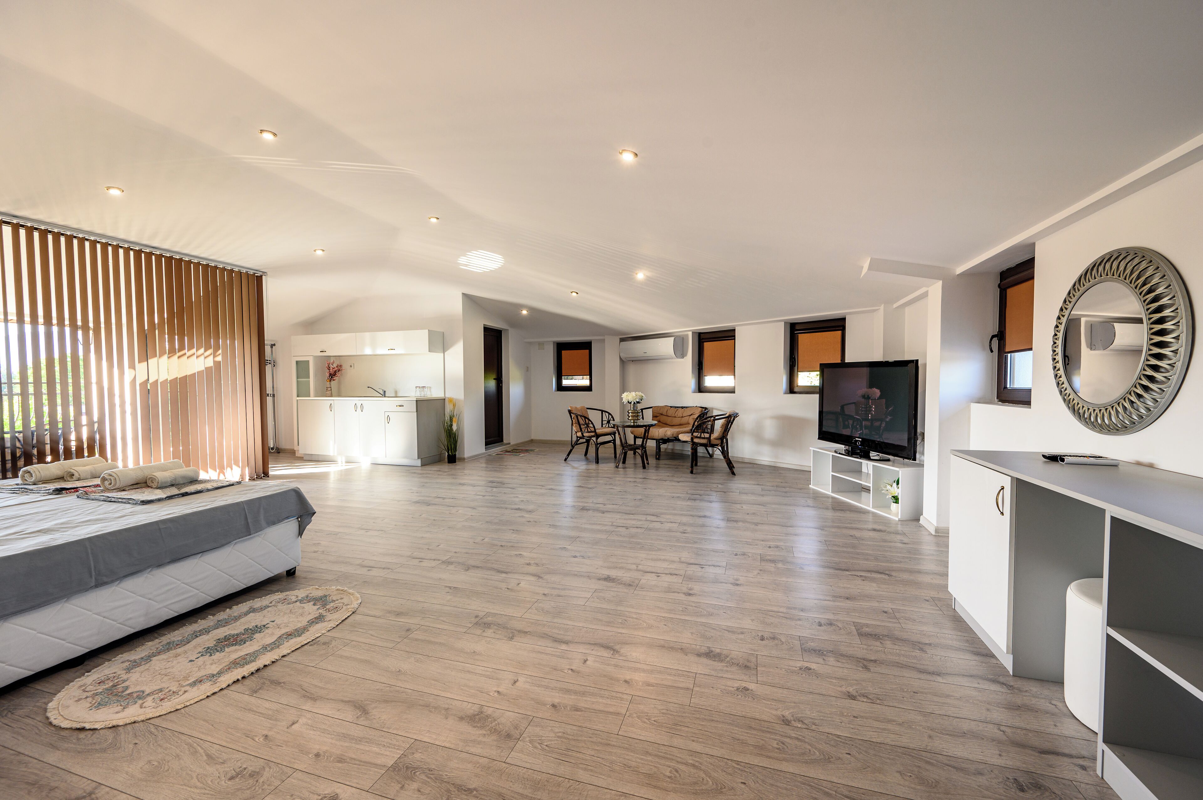 A spacious living area with a sofa, dining table, and TV.
