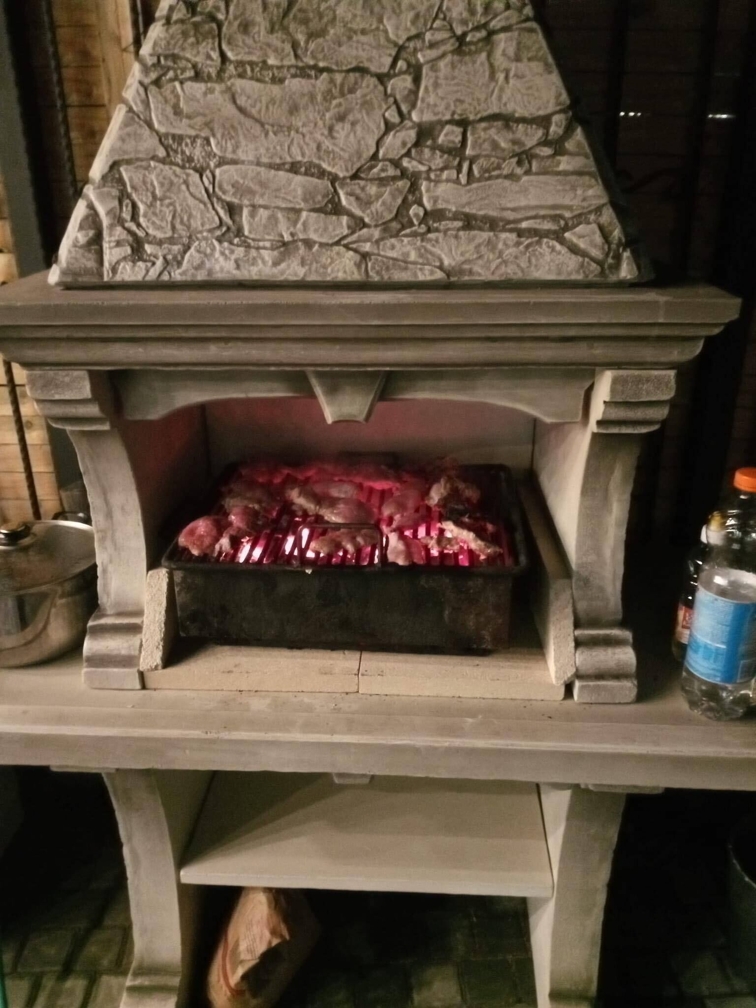 Un horno de piedra al aire libre con fuego encendido en su interior.