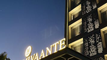 Exterior del Hotel Mivaante con señalización iluminada y un diseño arquitectónico moderno.