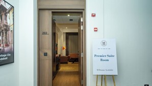 Pasillo de hotel con un cartel que indica una Habitación Suite Premier, con 10 habitaciones disponibles.