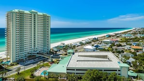 A high-rise hotel with a view of the beach and ocean.