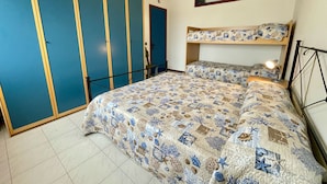A bedroom with a bunk bed, a large wardrobe, and a small window. - Bright Apartment Close to the Beach (Caorle)