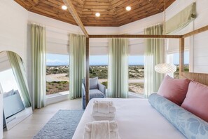 Un dormitorio con cama, sofá y vista a la playa.