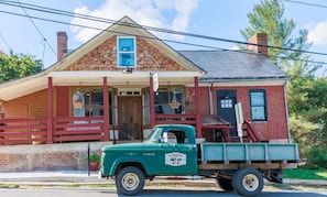 A vintage green truck parked in front of a brick building with a porch and a sign that reads "Old Brown's". - c1815, 3-bedroom Bed & breakfast in charming Historic Brownsburg with WiFi, AC (Rockbridge Baths)