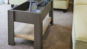 A modern living room with a sofa, a coffee table with a laptop, and a radiator.