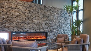 A stone wall, a fireplace, wicker furniture, and a potted plant. - Feeling Hotel (Beinan)