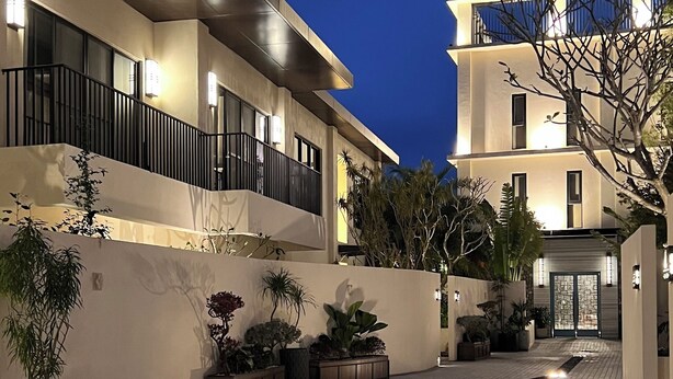 A modern building with a tiled courtyard, potted plants, and a well-lit entrance. - Feeling Hotel (Beinan)