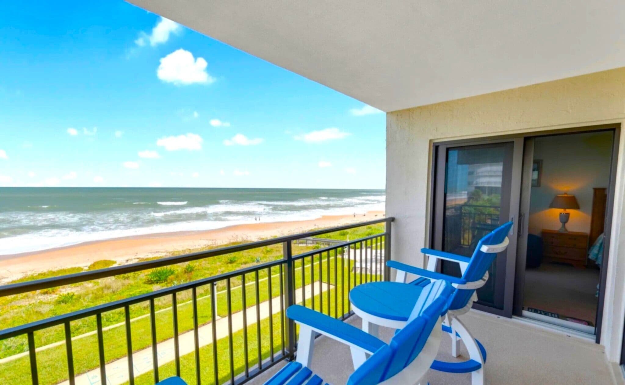 Ein Balkon mit Blick auf Strand und Meer.