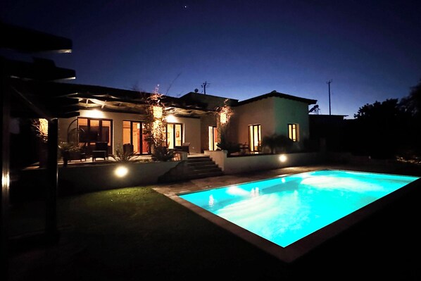Enjoy a refreshing dip in the pool surrounded by a beautifully maintained lawn and patio area.