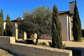 Experience a serene Mediterranean retreat amidst lush gardens and a historic stone facade.