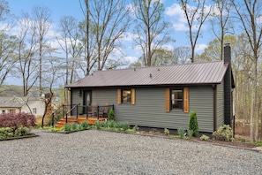 A single-story house with a metal roof, a front porch with a railing, and a chimney. - Waterfront Home - Hot Tub, Dock, Fire Pit, Boat (Lake Norman of Catawba)