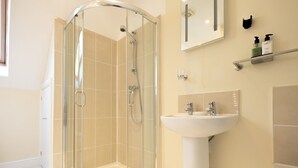 A modern bathroom with a glass-enclosed shower, a pedestal sink, and a mirror above the sink. - Cosy loft apartment near Oxford - Pass the Keys (Abingdon)