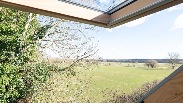 A view through a skylight of a green field and trees. - Cosy loft apartment near Oxford - Pass the Keys (Abingdon)