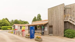 En bygning med en træfacade, en lille indgang og et skilt.