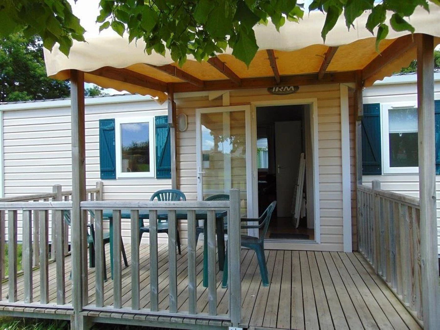 A covered porch with a wooden deck, a small table, and two chairs.