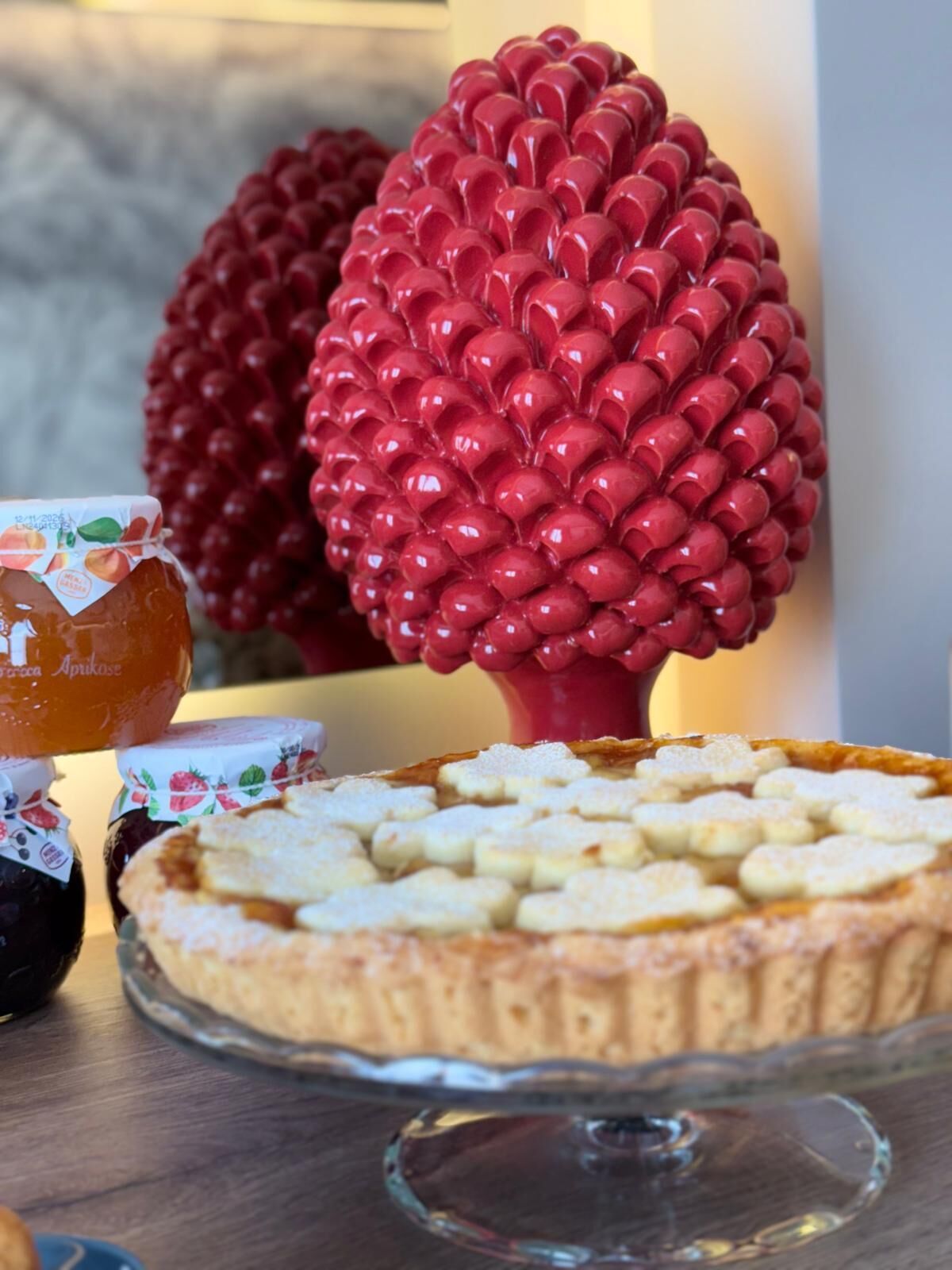 A dessert table with a pie and jars of preserves.