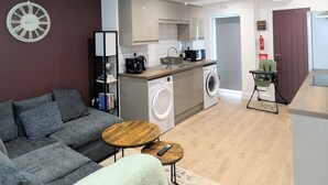 A modern apartment with a living room, kitchen, and laundry area. - Prime Location 5 Bed En-suite 6 Bathrooms in Derby Sleeps up to 10 People. (Derby)