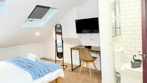 A bedroom with a bed, a desk, a chair, a TV, and a bathroom. - Prime Location 5 Bed En-suite 6 Bathrooms in Derby Sleeps up to 10 People. (Derby)