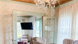 A dining area with a wooden ceiling, a chandelier, and a table set for six.
