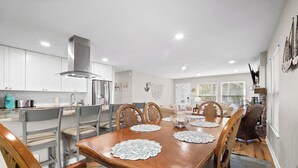 A modern kitchen with white cabinets, a stainless steel refrigerator, and a built-in stove. - Frippin Graytful, Golf Cart Included, Pet Friendly - 120 Sea Otter (Fripp Island)