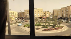 A residential area with multi-story buildings, a roundabout, and a few cars. - HOTEL 7DAYS (Dakhla)