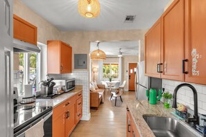 A kitchen with a dining area, featuring a microwave, sink, and cabinets.