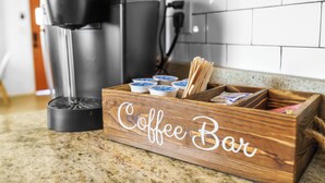 Una barra de café de madera con una cafetera y cápsulas de café.