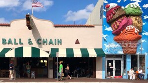 Un escaparate con un letrero que dice "BALL & CHAIN" y una bandera estadounidense.
