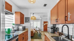 A modern kitchen with wooden cabinets, a granite countertop, a built-in oven, and a sink.