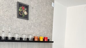 A modern kitchen with a black coffee machine, a black pot, a microwave, and a shelf with glass jars and colorful mugs. - --Niederrhein Kaue-- your cozy vacation apartment directly behind the dike. (Voerde (Niederrhein))