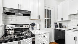 A modern kitchen with white cabinets, a stainless steel stove, and a black dishwasher. - Charming 2-bedroom apartment in dowtown Decatur/ 20 min from downtown ATL (Decatur)