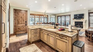 Una cocina amplia con una isla grande, armarios de madera y una chimenea.