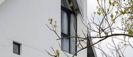 Un edificio moderno con fachada blanca, múltiples ventanas y techo inclinado.