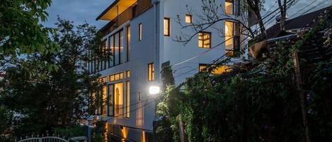 A modern two-story house with a paved driveway and a gated entrance.