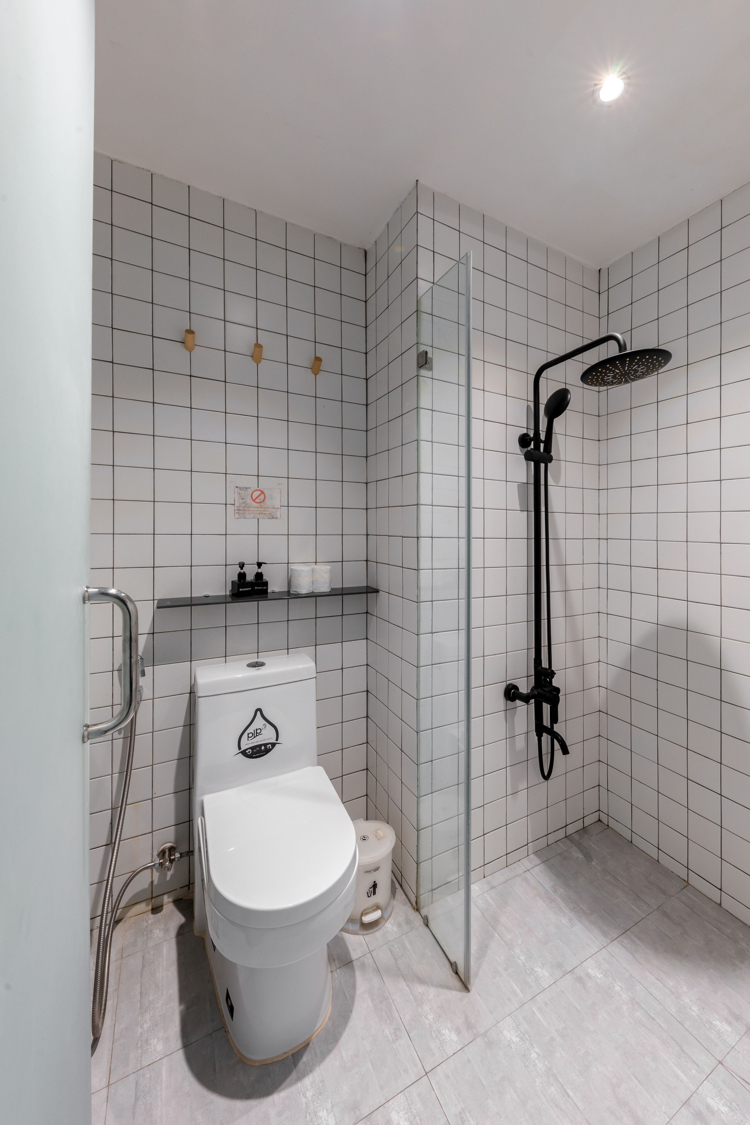 Une salle de bain équipée de toilettes, d’une douche et d’une barre d’appui.