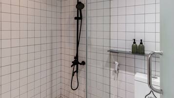 A bathroom with a shower, a toilet, and a sink.
