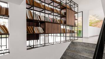 A modern interior with a staircase, a built-in bookshelf, and a view of the outdoors.